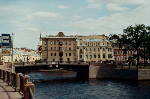 Free A picturesque view of a canal with a historic bridge and colorful buildings in St. Petersburg, Russia. Stock Photo