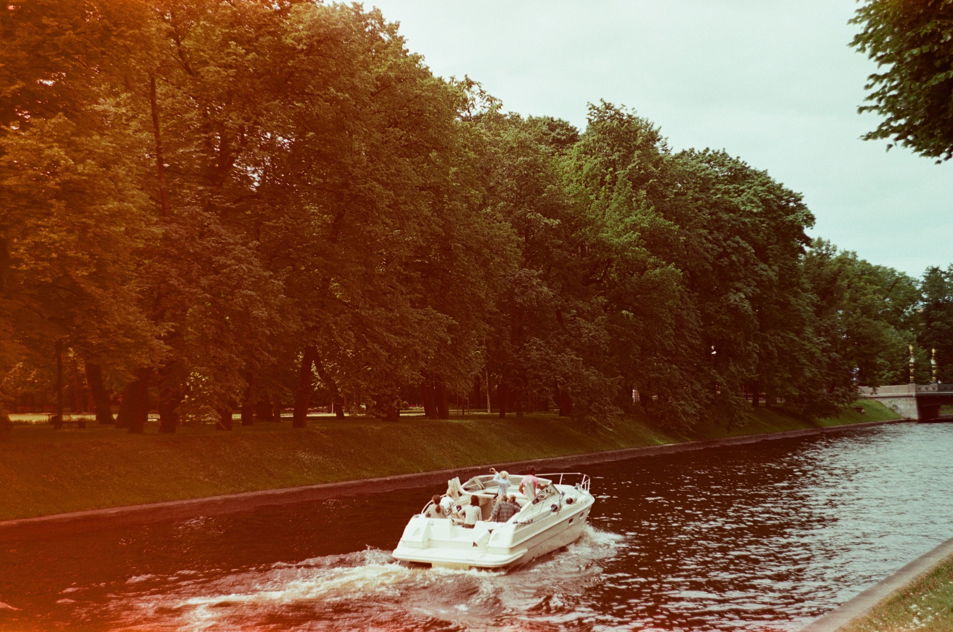 Bateau à moteur avançant sur un canal bordé d’arbres