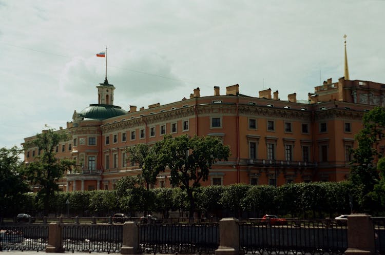 Trees Beside Mikhailovsky Castle With Flag On Top In St Petersburg