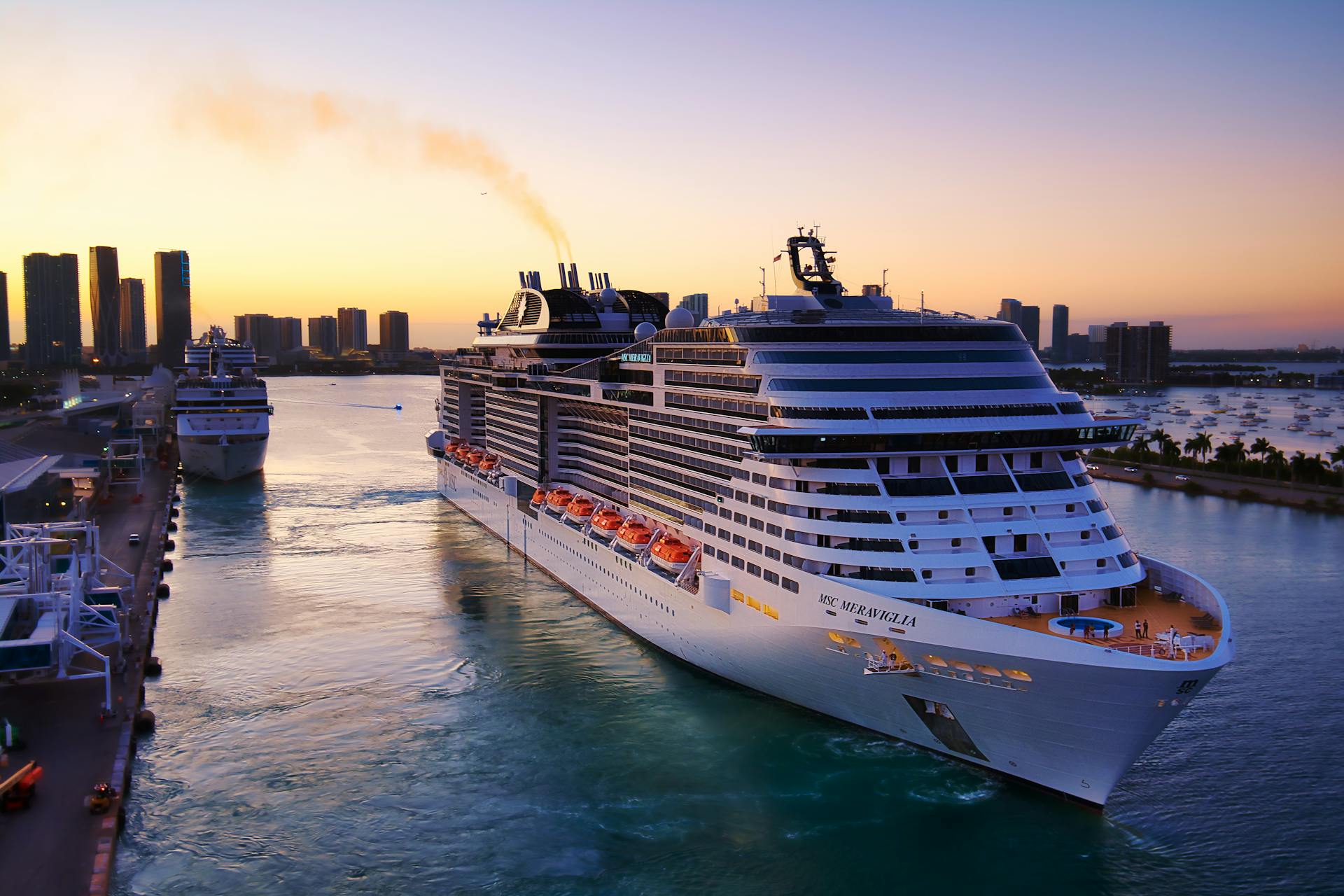 Stunning aerial view of cruise ships in Miami harbor at sunset, showcasing city skyline and vibrant colors.