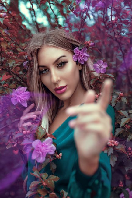 A captivating portrait of a young woman in a floral setting exuding vibrant elegance.