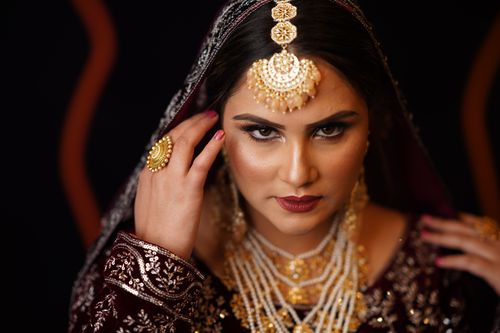 Free Close-up portrait of a stunning South Asian bride showcasing traditional jewelry and intricate makeup. Stock Photo
