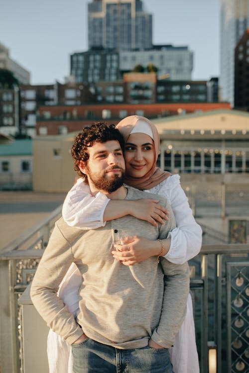Woman in Hijab Embracing Man in Gray Long Sleeve Shirt