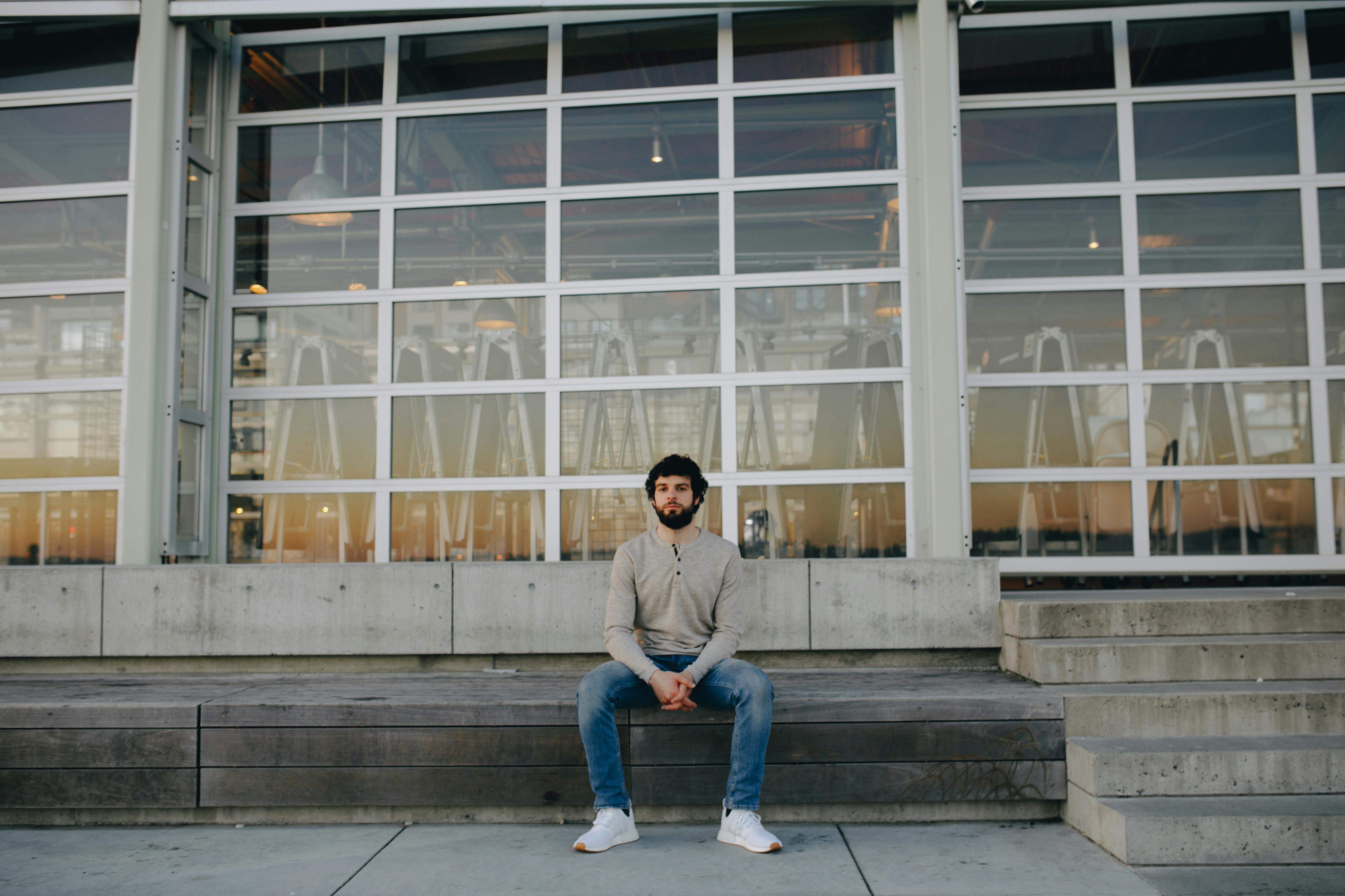 Man Sitting on Bench Having a Cup of Coffee · Free Stock Photo