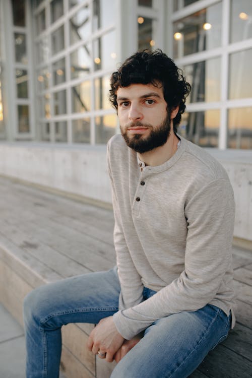 A Bearded Man in Gray Sweater and Denim Jeans