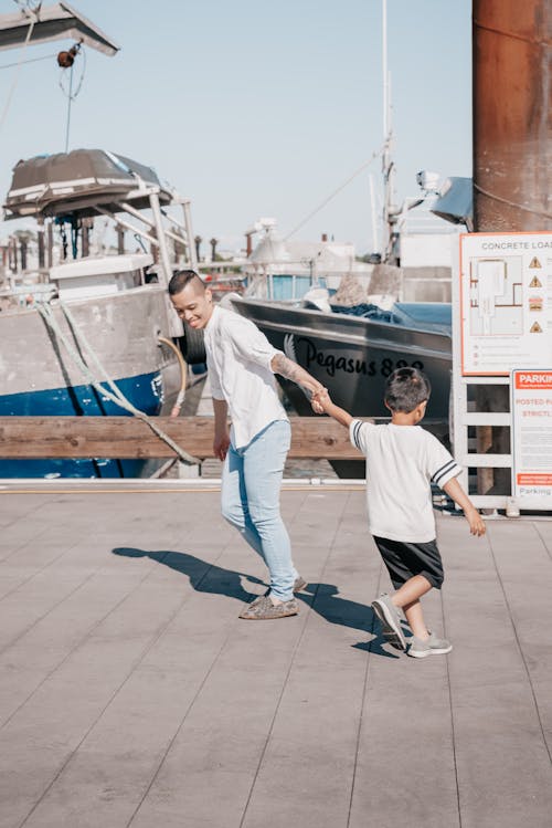 Free Dad and Son Playing Together on Wooden Dock Stock Photo