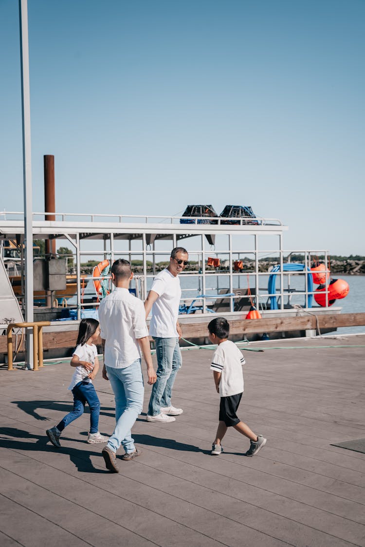 A Family Walking Together On A Boardwalk