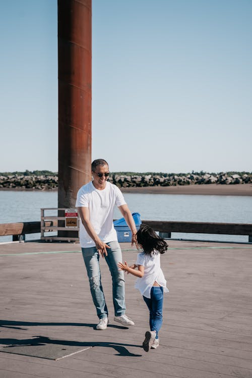Dad and Daughter Playing Together on Wooden Dock