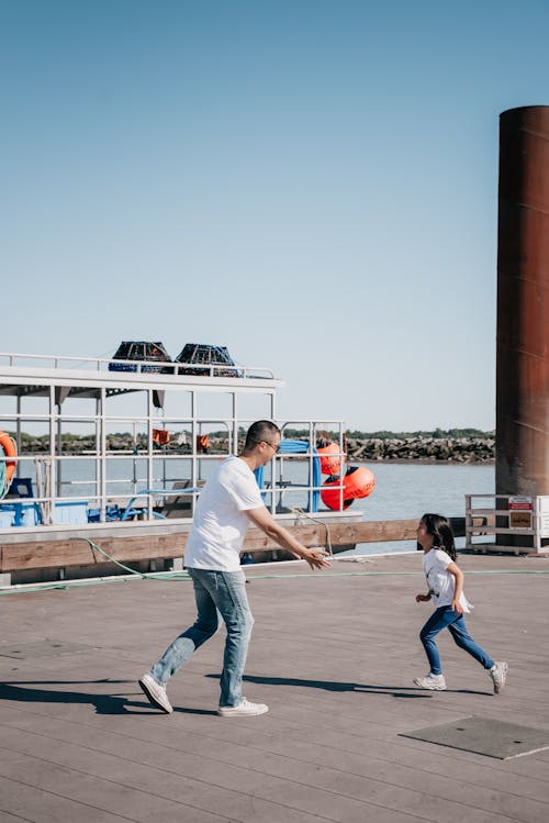 Dad and Daughter Playing Together on Wooden Dock