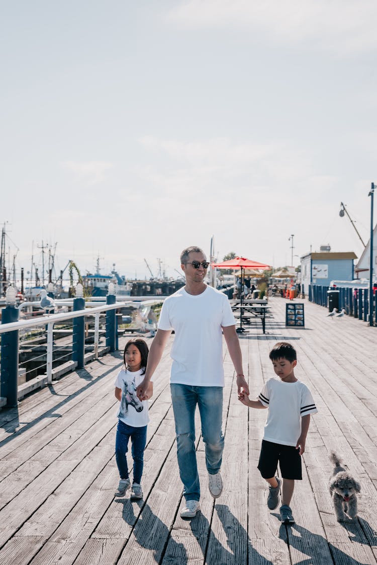 A Family Walking Together On A Boardwalk