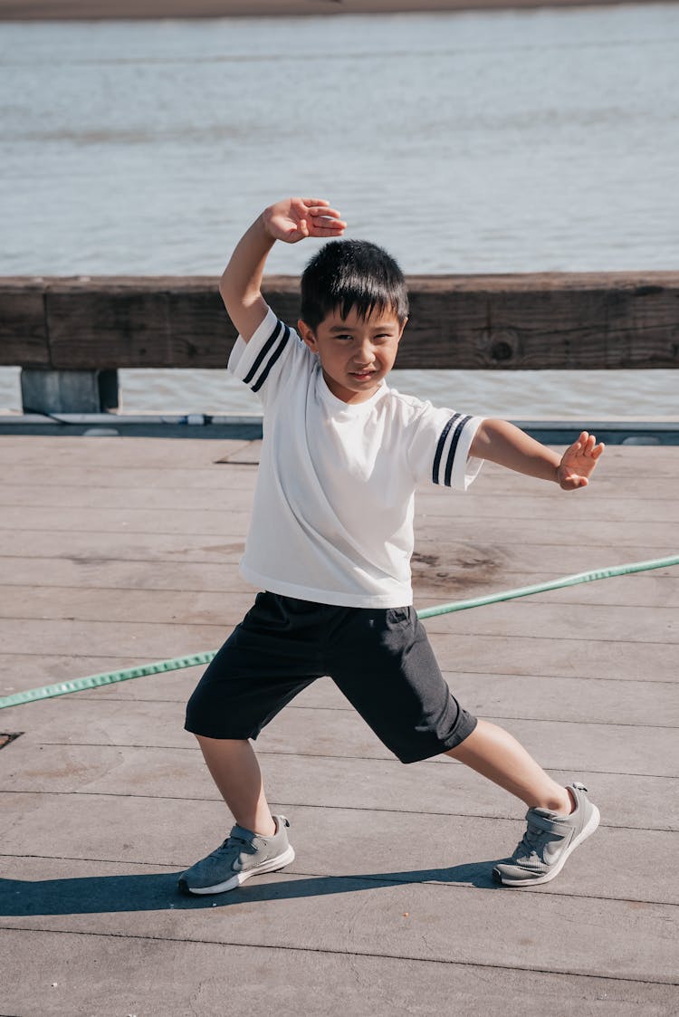 Cute Boy In White Shirt Doing A Fighting Pose