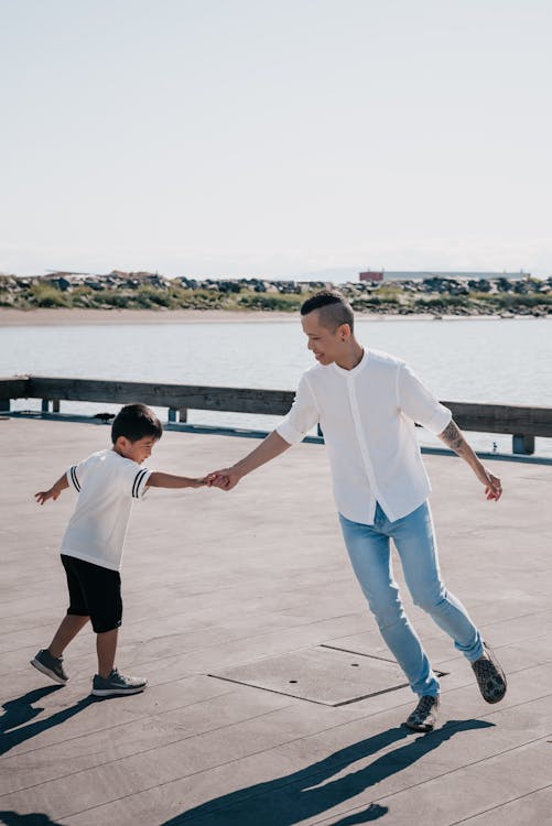 Free Dad and Son Playing Together on Wooden Dock Stock Photo