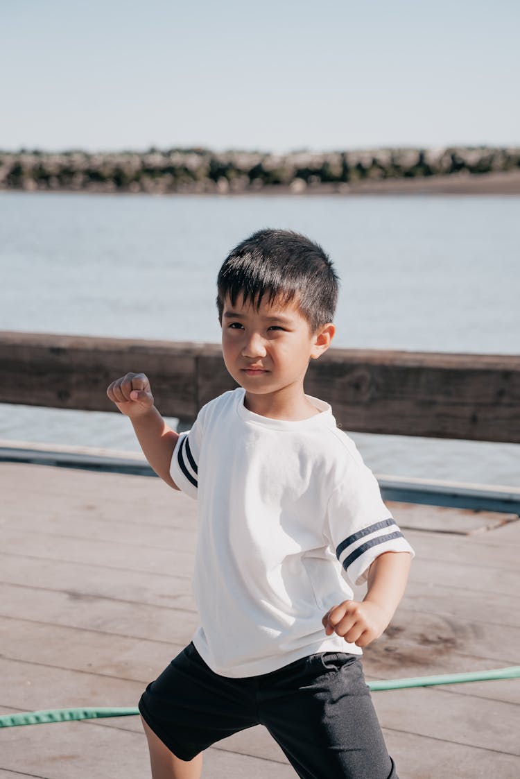 Cute Boy In White Shirt Doing A Fighting Pose