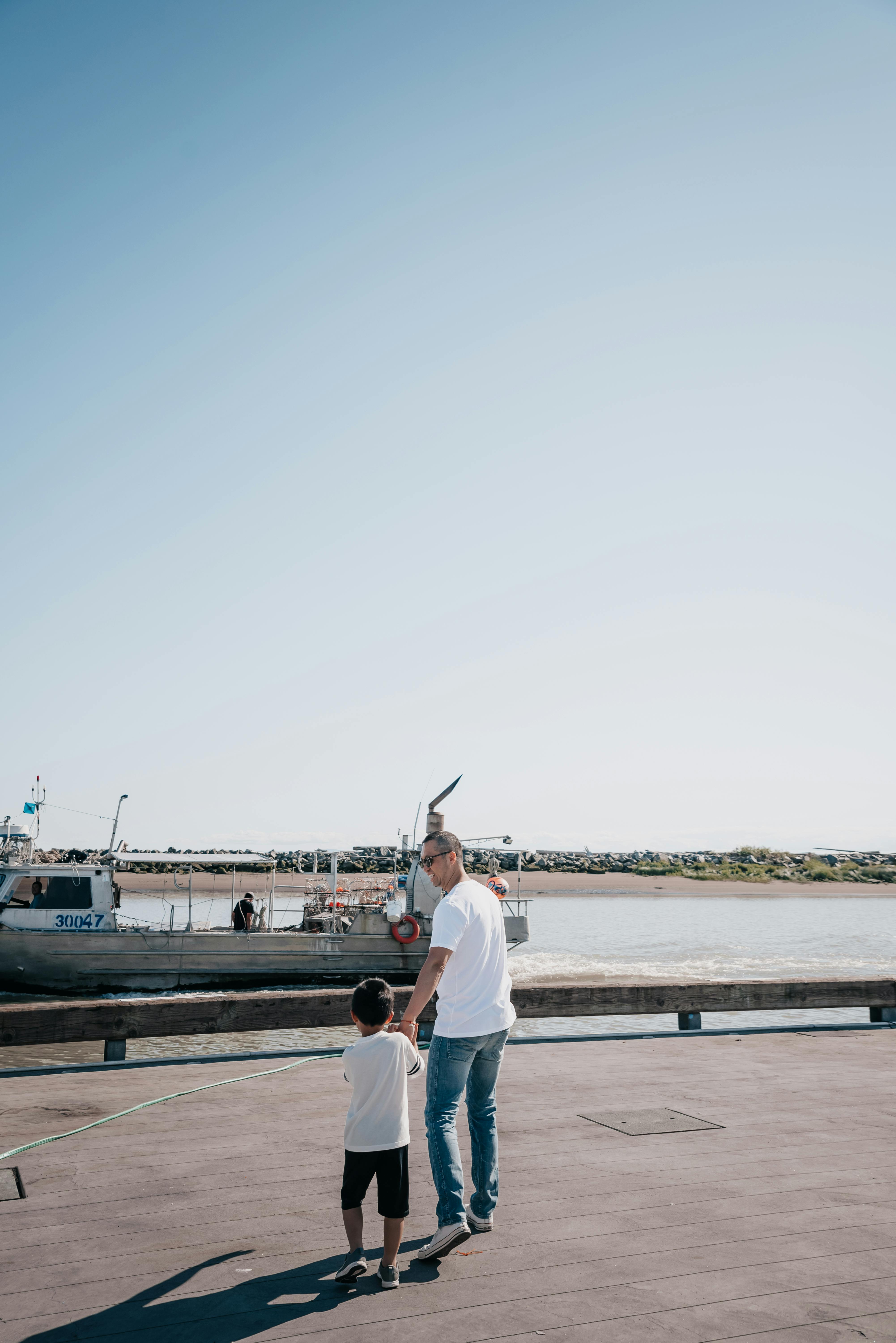 dad and son walking together on a boardwalk