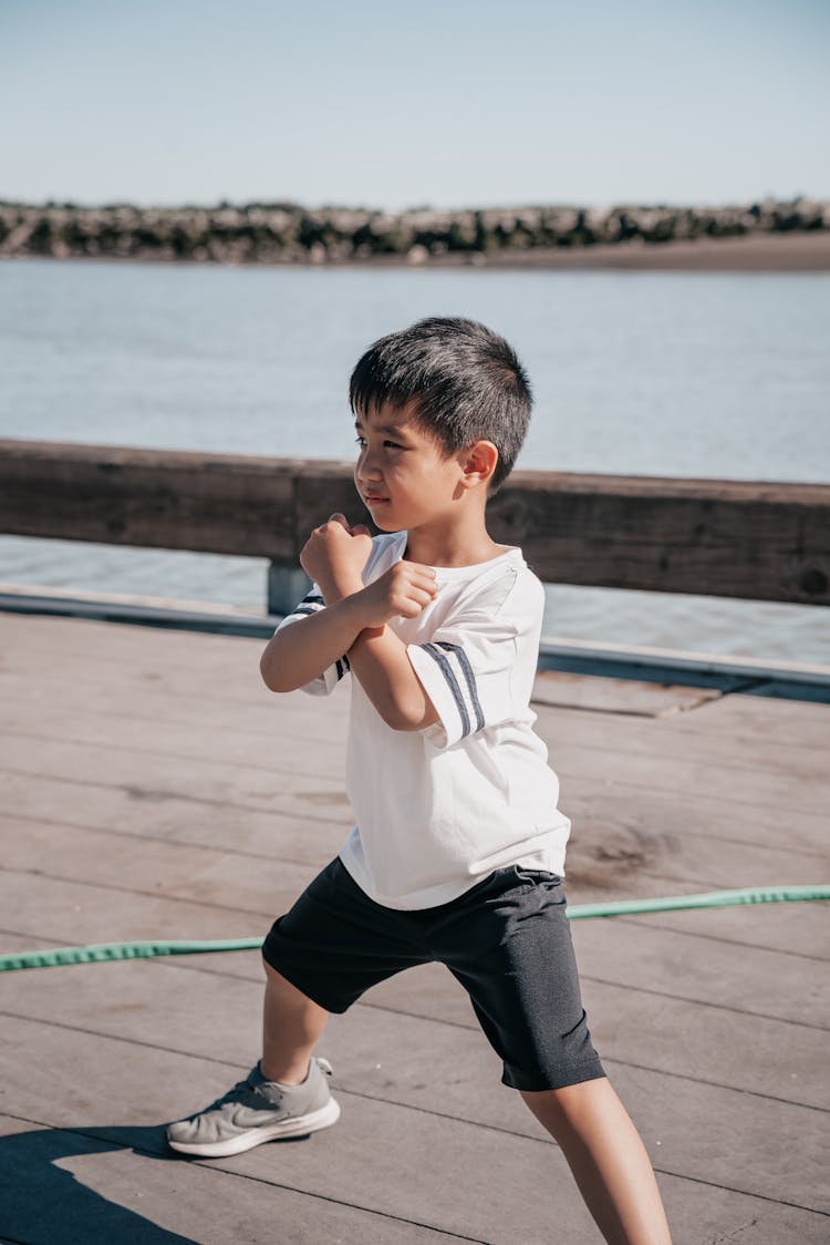 Cute Boy In White Shirt Doing A Fighting Pose