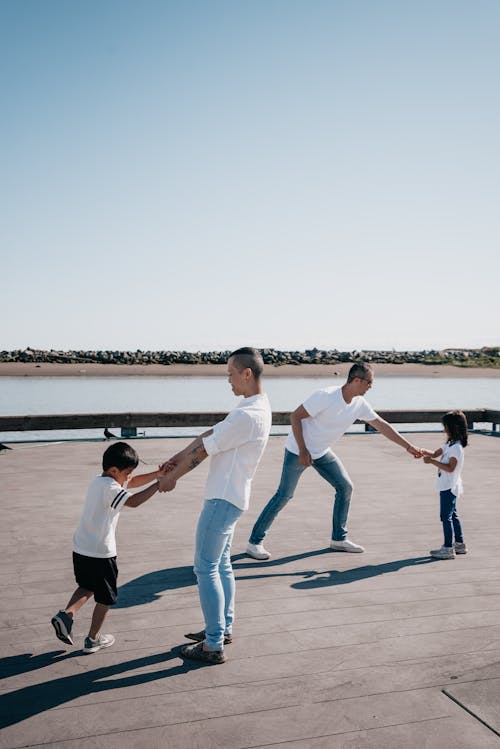 Dads Playing Together with Their Kids on Wooden Dock