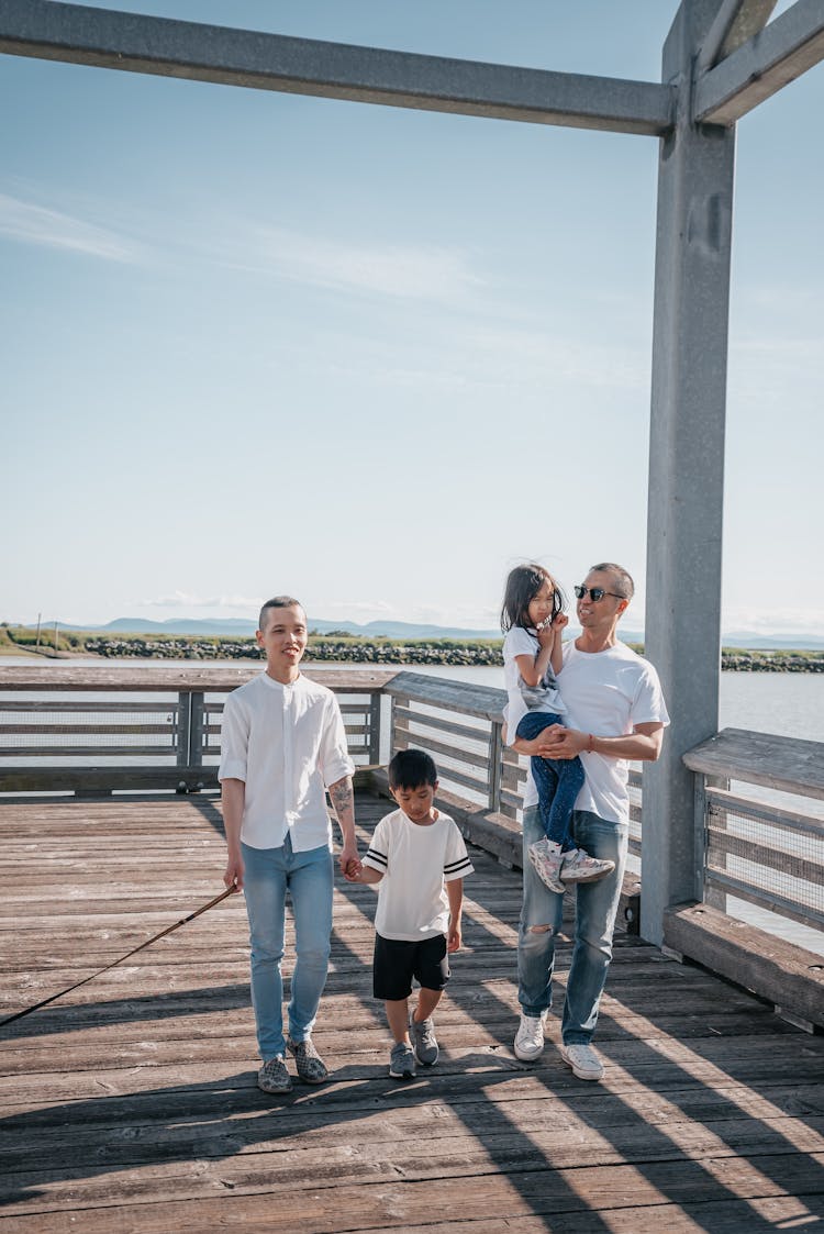 A Family Walking Together On A Boardwalk