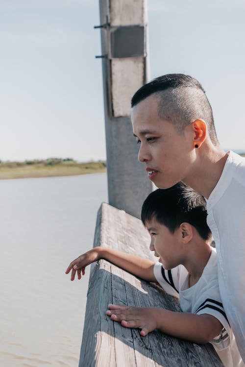 Free Dad and Son Standing Together near the Wooden Railing Stock Photo