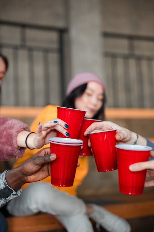 People Holding Red Disposable Cups