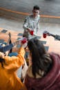 Man in Gray and White Long Sleeve Shirt Holding Red Plastic Cup