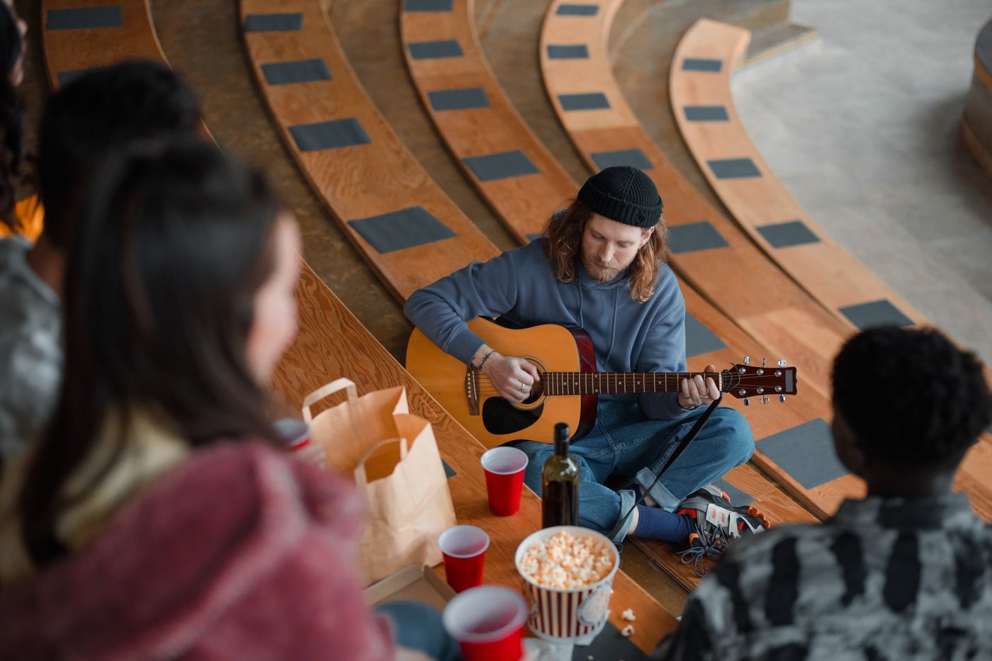 Friends sharing tea and listening to music together on the floor