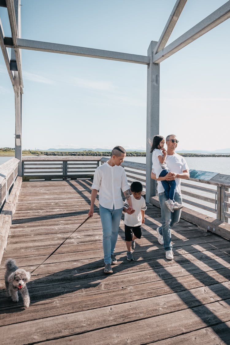 A Family Walking Together On A Boardwalk