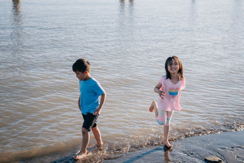 Boy and Girl Playing at the Beach Shore
