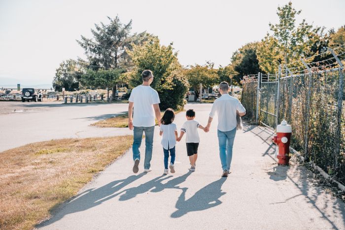 Family of four holding hands while walking together
