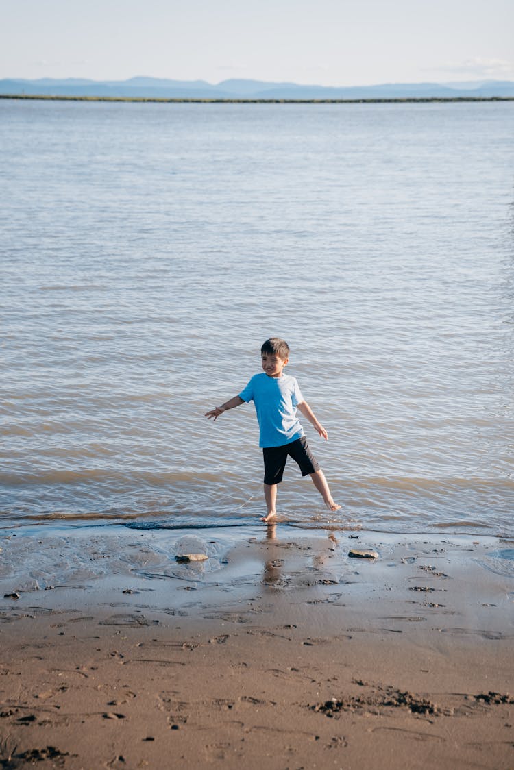 A Boy Walking At The Beach