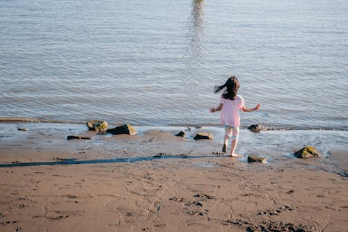 Child Walking Along The Beach