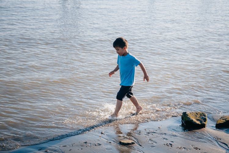 A Boy Running At The Beach