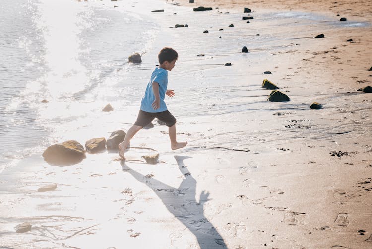 A Boy Running At The Beach