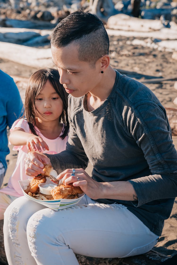 Parent And A Child Sharing Food