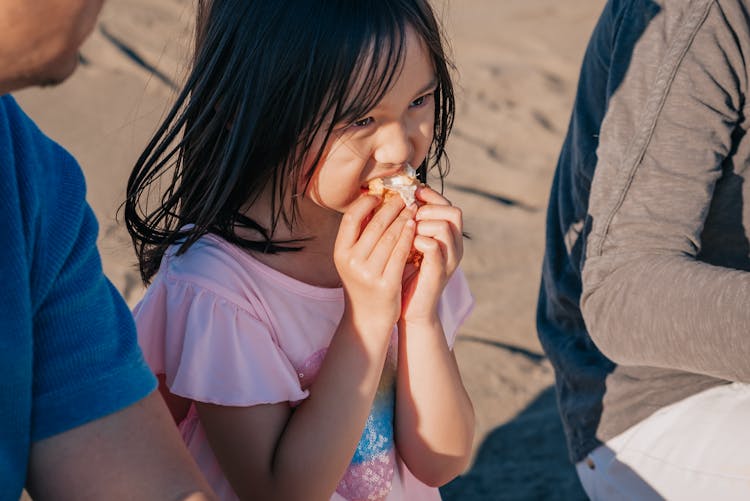 Girl In Pink Shirt Eating A Snack