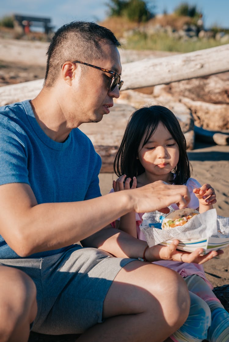 Dad And Daughter Eating A Snack