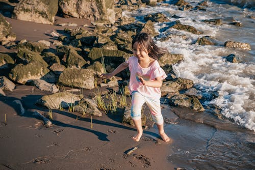 Young Girl Running on a Rocky Shore