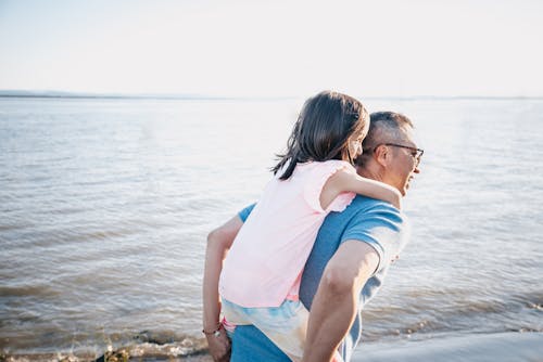 Free Father Carrying his Daughter on his Back Stock Photo
