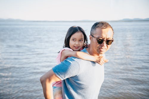 Free Father Carrying his Daughter on his Back  Stock Photo