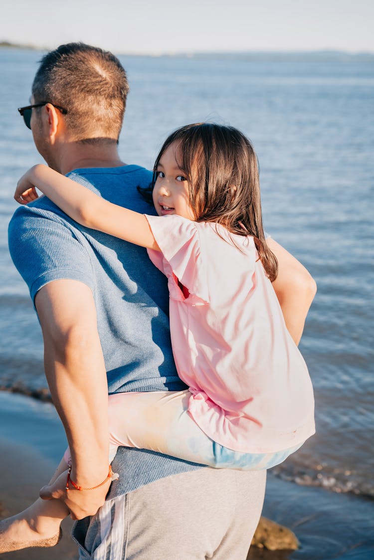 Dad Carrying Her Cute Daughter At The Beach