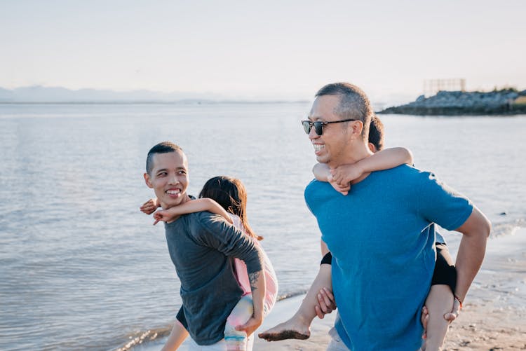 Dads Carrying Their Children At The Beach