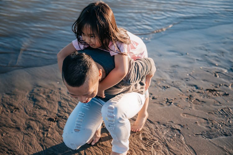 Dad Carrying His Cute Daughter On The Beach