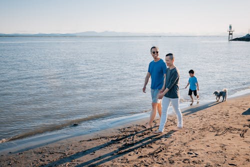 Free A Happy Family Walking on the Beach Stock Photo
