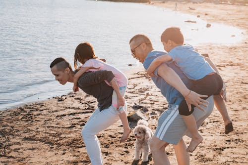 Free Dads Carrying Their Children at the Beach Stock Photo