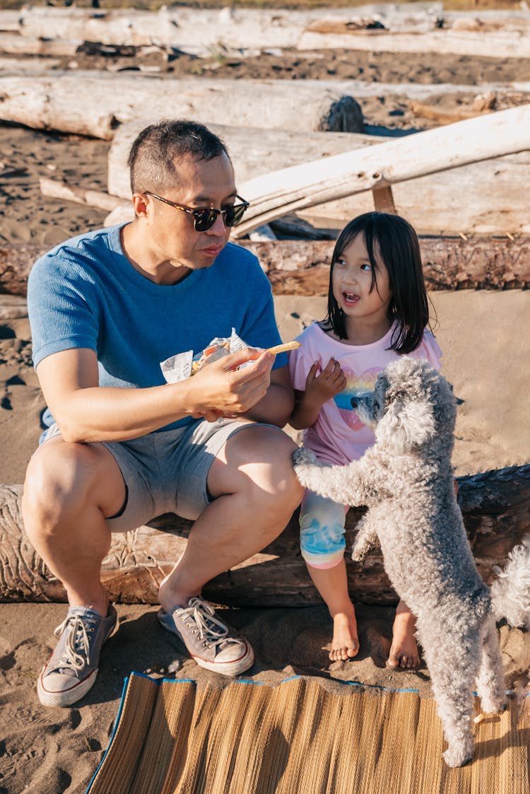 Dad And Daughter Feeding Their Dog