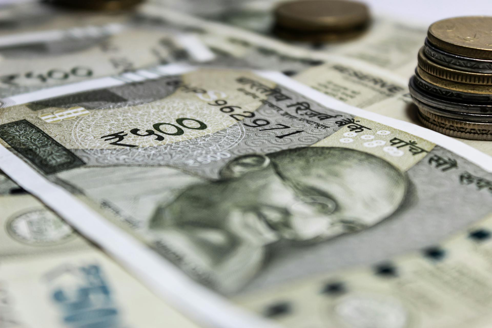 Detailed close-up of Indian rupees and coins, symbolizing economy and finance.