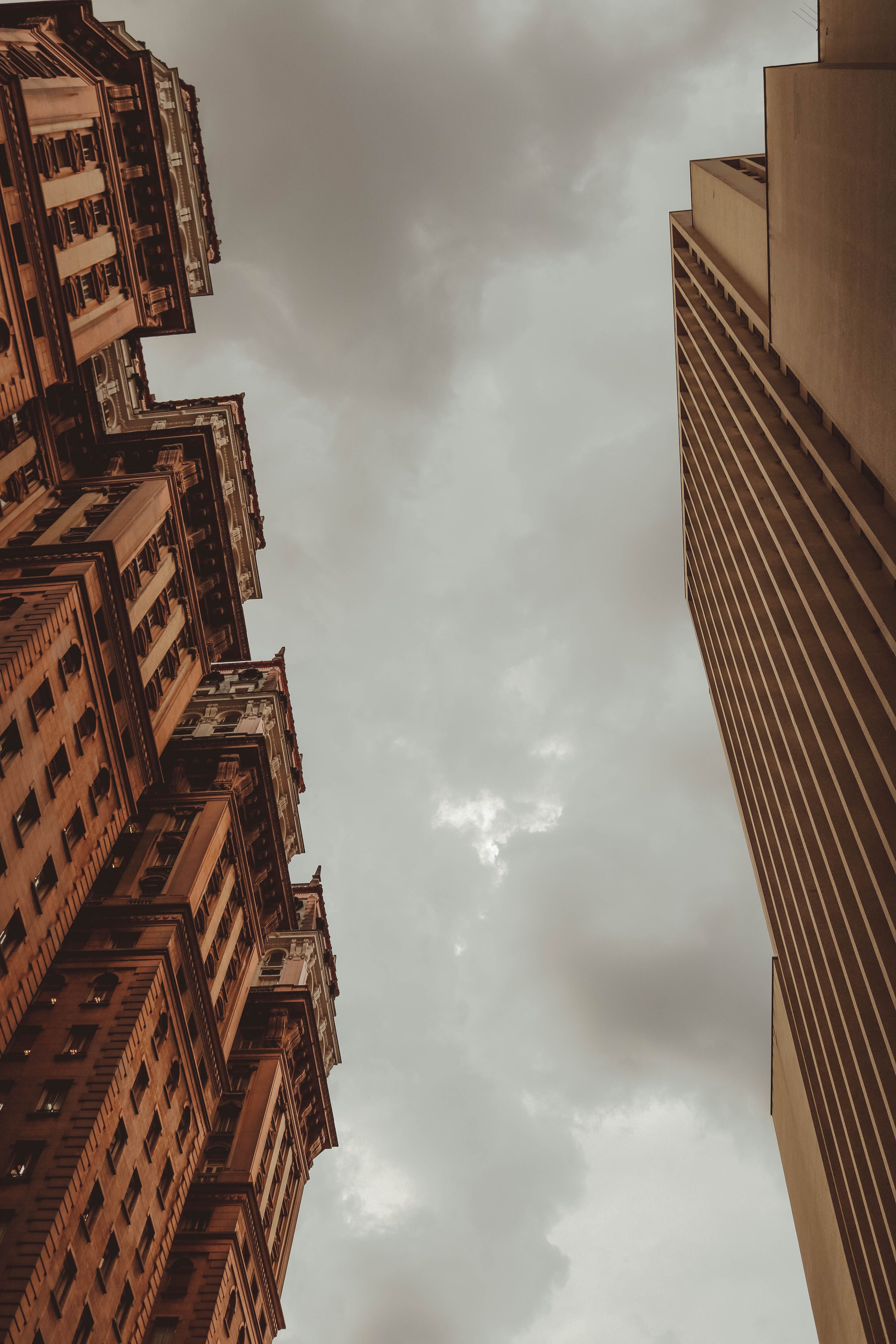 Low Angle Shot of Brown Concrete Building Under White Clouds · Free ...