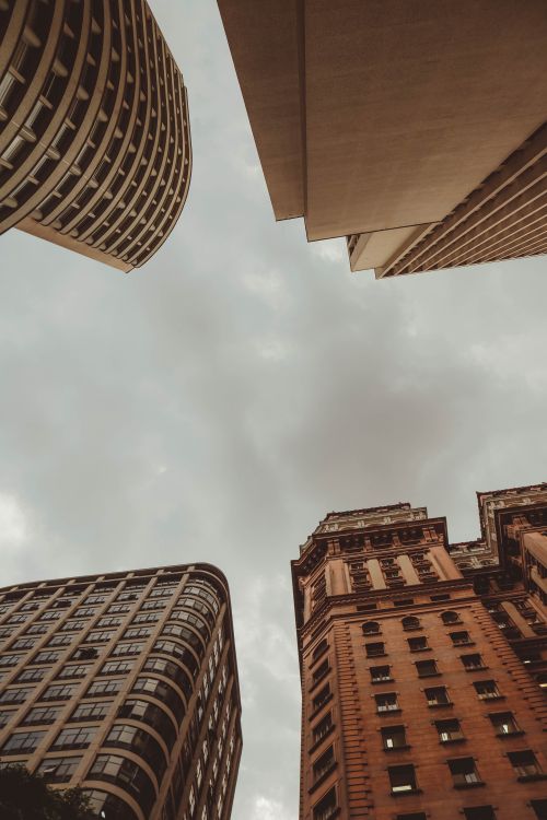 Free A striking urban skyline with towering skyscrapers under a moody, overcast sky. Stock Photo