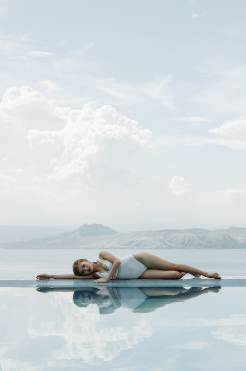 Free A Woman Lying Down Near the Water Stock Photo