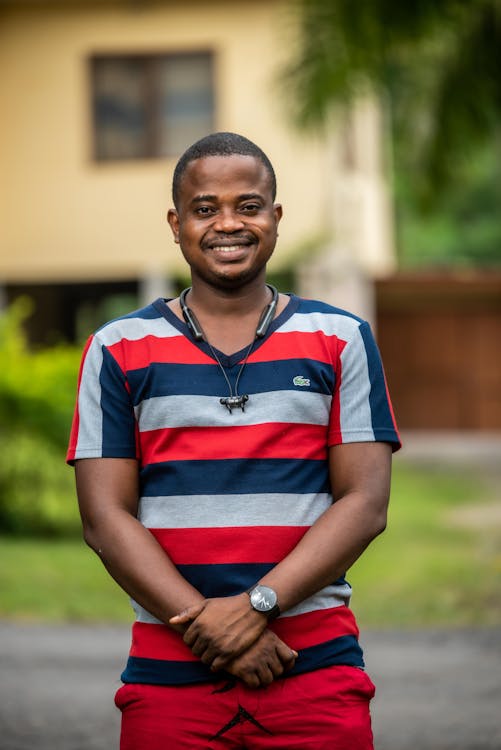 A Man in Striped Shirt Standing while Looking at the Camera