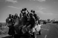 Grayscale Photo of People Sitting on Car